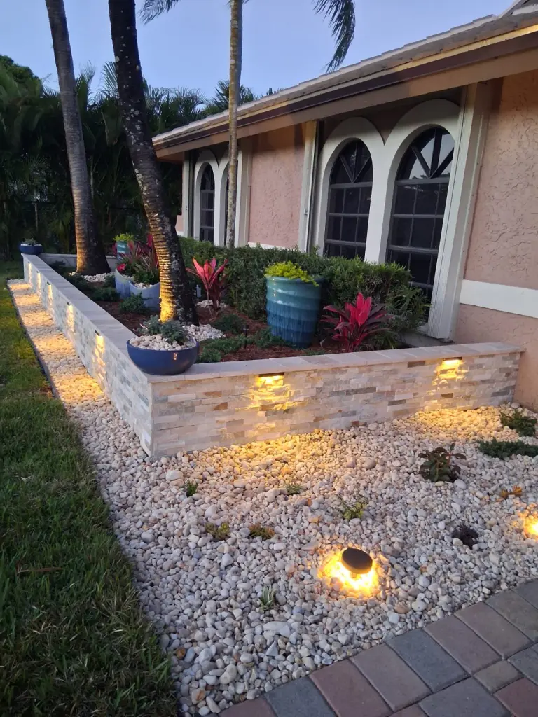 Veneer block border with built-in lights around a white rock bed