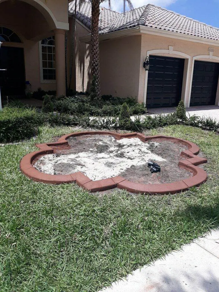 Flower-shaped red concrete border ring set into a lawn